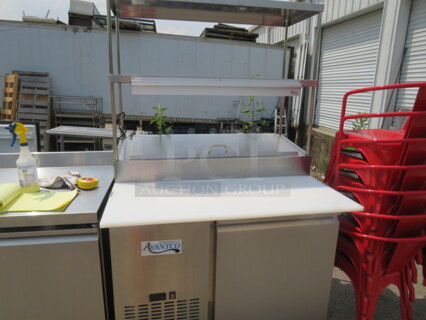 One Stainless Steel Avantco 1 Door Refrigerated Prep Table With 2 SS Over Shelves, 1 Rack, 36 Inch Ticket Rail, And  Cutting Board On Casters. Model# 178SSPPT-1. 115 Volt. 44.5X37X73. 