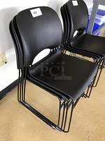 Three Black Plastic Stackable Chairs
