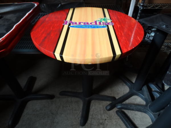 Round Table on Black Metal Table Leg w/ Paradise Logo. Stock Picture - Cosmetic Condition May Vary. 24x24x29 - Image 1 of 4
