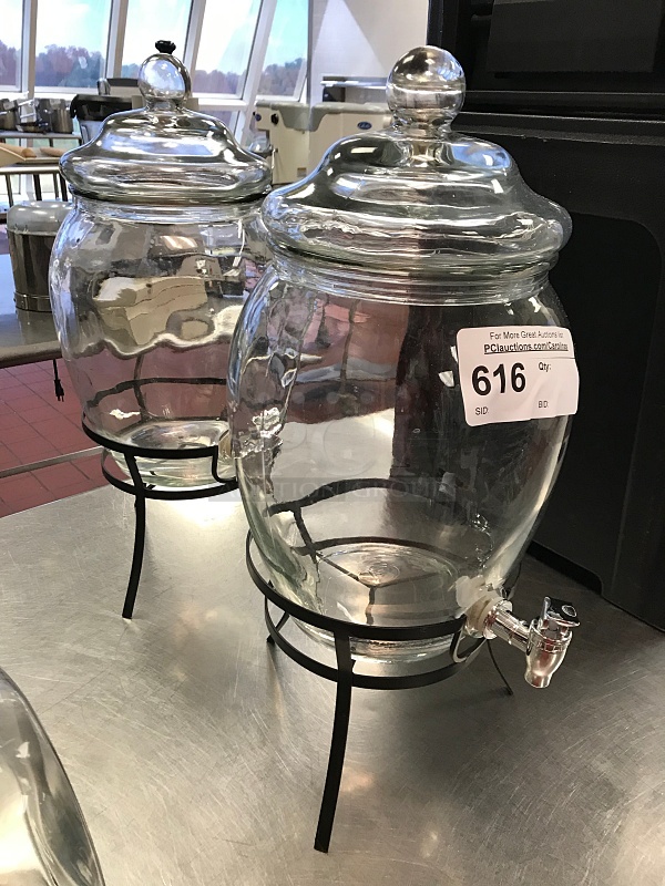 Two Glass Water Dispensers on Black Metal Stands