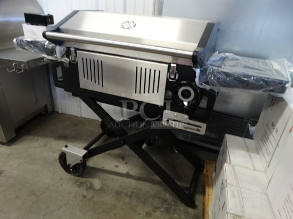 BRAND NEW IN BOX! Glaros Model BBQP-SS Stainless Steel Portable BBQ Grill on Casters. Comes w/ Rotisserie Spit, 2 Cooking Stones and Cover! Stock Picture Used To Show Item - Comes Disassembled In Box. 56x21x41 - Image 2 of 11