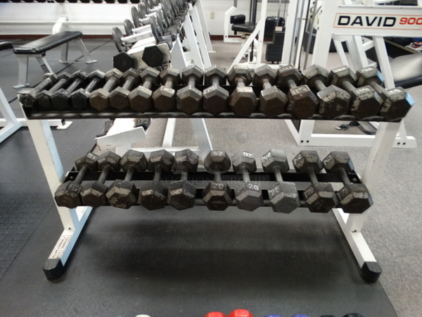 ALL ONE MONEY! Lot of White and Black Metal 2 Tier Dumbbell Rack w/ 13 Sets of Metal Dumbbells In Picture. Four 5 Pound, Two 8 Pound, Two 10 Pound, Two 12 Pound, Six 15 Pound, Four 20 Pound and Four 25 Pound. 52x19x27