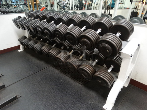 ALL ONE MONEY! Lot of Tuff Stuff White and Black 2 Tier Dumbbell Rack w/ 10 Sets of Dumbbells Shown In Pictures: 105 Pounds, 110 Pounds, 115 Pounds, 120 Pounds, 125 Pounds, 130 Pounds, 135 Pounds, 140 Pounds, 145 Pounds and 150 Pounds.