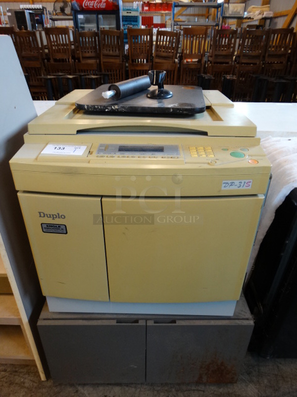 Duplo Model DP-31S Printer on Gray Stand w/ 2 Doors. 29x24x43