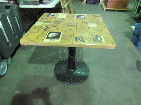 Laminate Table Top With A Rounded Edge And Assorted Advertisements On A Decorative Pedestal Base. 32X32X30