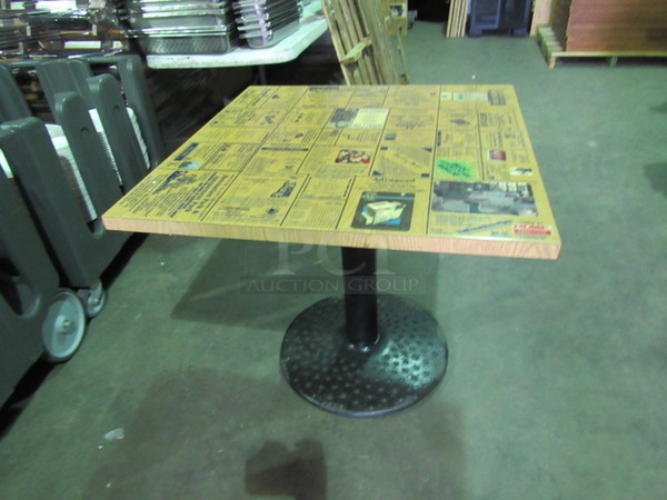 Laminate Table Top With A Square Edge And Assorted Advertisements On A Decorative Pedestal Base. 32X32X30