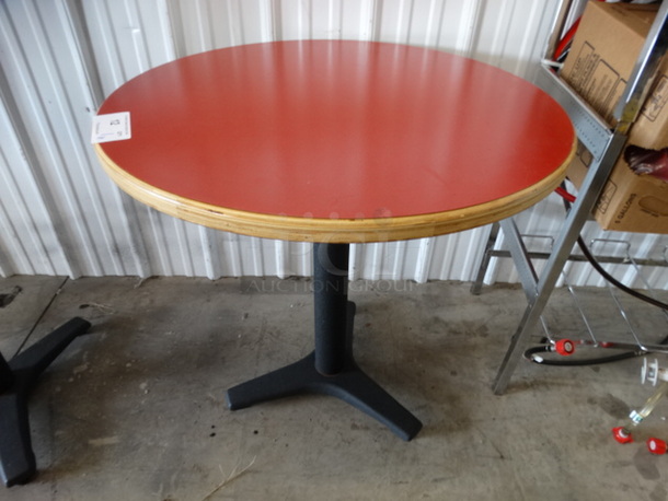 Round Red Table on Black Metal Table Base. Stock Picture - Cosmetic Condition May Vary. 30x30x30