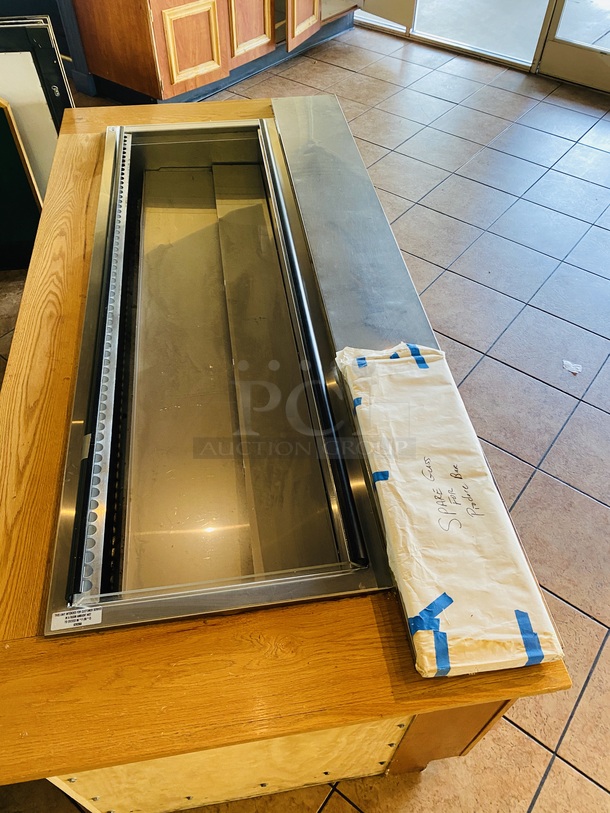 BEAUTIFUL!! Delfield N8182-FA, Forced Air Cold Pan Drop-In Unit. In Perfect Working Order. Unit holds up to (6) 12x20 Pans, 3/4 HP, 14.8Amp, 115v, 5-20 Nema Plug.     Lot Consists of: Solid Wood Serving Station, Free Standing Produce Bar with Forced Air Cold Pan Drop-In Unit on Commercial Casters, 3 Pane Glass Sneeze Guard Mounted Underneath Mirrored Angled Storage Shelf with 13 Stylish Open Top Wood Containers. Includes Extra Glass Panes. Delfield N8182-FA, Forced Air Cold Pan Drop-In Unit - 82.25” x 26.67” x 28.62” - hold up to (6) 12x20 Pans, 3/4 HP, 14.8Amp, 115v, 5-20 Nema Plug. Produce Bar is plated with stainless steel to protect the wood surface and allow for ease in sliding tray and cleaning. Overall dimensions: 103-1/2x44x72 Produce Bar/Cabinet: 100x45-1/2x33.  This piece is located on site in Modesto, CA. Shipping or Pick-Up Available. Winning Bidder must Contact PCI Auctions Southwest by 26-AUG-2020 with Arrangements for pick-up or shipping. Pick-Up for this items will not  - Image 7 of 9
