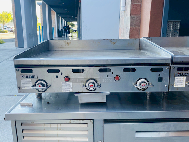 BUILT FOR HEAVY USE! Vulcan MSA-36-101 36" Countertop Natural Gas Griddle with Snap-Action Thermostatic Controls - 81,000 BTU. Width 36 Inches Depth 31 1/2 Inches Height 15 1/4 Inches Cooking Surface Width 36 Inches Cooking Surface Depth 24 Inches Stainless steel front, sides and front top ledge. Fully welded stainless and aluminized steel body frame. 11" low profile cooking height on 4" legs. 1" thick polished steel griddle plate with 12 gage, 4" stainless steel back and tapered side splashes. Grease chute is fully welded to stop grease migration. One 27,000 BTU/hr. “U” shaped aluminized steel burner and mechanical snap action thermostat for each 12" of griddle width. Chrome thermostat knob guards. Temperature adjusts from 200° to 550° F. One pilot safety for every two burners. - Image 2 of 8
