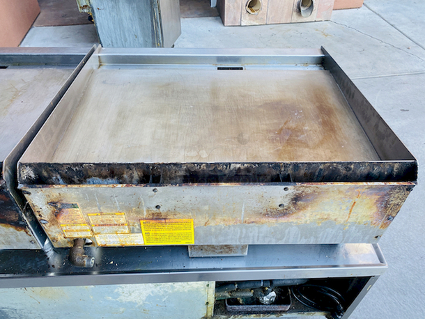BUILT FOR HEAVY USE! Vulcan MSA-36-101 36" Countertop Natural Gas Griddle with Snap-Action Thermostatic Controls - 81,000 BTU. Width 36 Inches Depth 31 1/2 Inches Height 15 1/4 Inches Cooking Surface Width 36 Inches Cooking Surface Depth 24 Inches Stainless steel front, sides and front top ledge. Fully welded stainless and aluminized steel body frame. 11" low profile cooking height on 4" legs. 1" thick polished steel griddle plate with 12 gage, 4" stainless steel back and tapered side splashes. Grease chute is fully welded to stop grease migration. One 27,000 BTU/hr. “U” shaped aluminized steel burner and mechanical snap action thermostat for each 12" of griddle width. Chrome thermostat knob guards. Temperature adjusts from 200° to 550° F. One pilot safety for every two burners. - Image 5 of 8