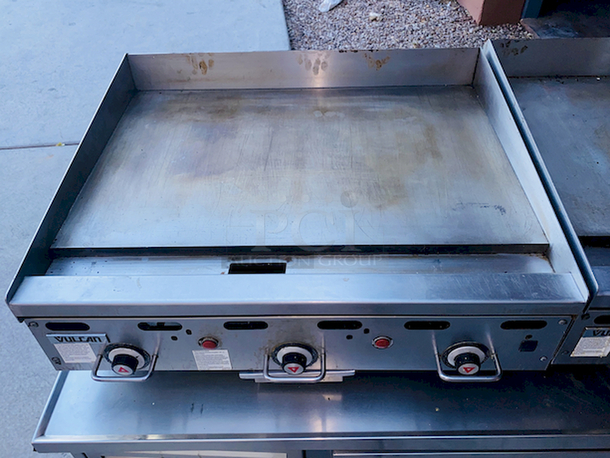 BUILT FOR HEAVY USE! Vulcan MSA-36-101 36" Countertop Natural Gas Griddle with Snap-Action Thermostatic Controls - 81,000 BTU. Width 36 Inches Depth 31 1/2 Inches Height 15 1/4 Inches Cooking Surface Width 36 Inches Cooking Surface Depth 24 Inches Stainless steel front, sides and front top ledge. Fully welded stainless and aluminized steel body frame. 11" low profile cooking height on 4" legs. 1" thick polished steel griddle plate with 12 gage, 4" stainless steel back and tapered side splashes. Grease chute is fully welded to stop grease migration. One 27,000 BTU/hr. “U” shaped aluminized steel burner and mechanical snap action thermostat for each 12" of griddle width. Chrome thermostat knob guards. Temperature adjusts from 200° to 550° F. One pilot safety for every two burners. - Image 7 of 8