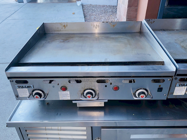 BUILT FOR HEAVY USE! Vulcan MSA-36-101 36" Countertop Natural Gas Griddle with Snap-Action Thermostatic Controls - 81,000 BTU. Width 36 Inches Depth 31 1/2 Inches Height 15 1/4 Inches Cooking Surface Width 36 Inches Cooking Surface Depth 24 Inches Stainless steel front, sides and front top ledge. Fully welded stainless and aluminized steel body frame. 11" low profile cooking height on 4" legs. 1" thick polished steel griddle plate with 12 gage, 4" stainless steel back and tapered side splashes. Grease chute is fully welded to stop grease migration. One 27,000 BTU/hr. “U” shaped aluminized steel burner and mechanical snap action thermostat for each 12" of griddle width. Chrome thermostat knob guards. Temperature adjusts from 200° to 550° F. One pilot safety for every two burners. - Image 8 of 8