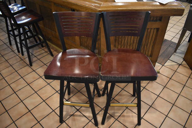 2 Black Metal Bar Height Swivel Chairs w/ Wooden Seats and Wooden Backrest. Stock Picture - Cosmetic Condition May Vary. 18x16x42. 2 Times Your Bid!