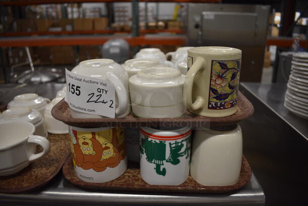 22 Various Ceramic Mugs on 2 Brown Trays. Includes 4.5x3.5x3.5. 22 Times Your Bid!