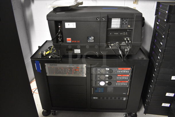 MARVELOUS! 2012 Barco Model DP2K-12C Commercial Countertop DLP Cinema Projector on Cabinet w/ Film-Tech FT21 Automation Cinema System, 4 Dolby CP750 Digital Cinema Processors, DCM Powercom, TV Monitor and Tripp Lite Surge Protector. 200-240 Volts. See Lot 4 For Additional Pictures! 26x38x22, 24x53x38. BUYER MUST REMOVE. Tested and Working!