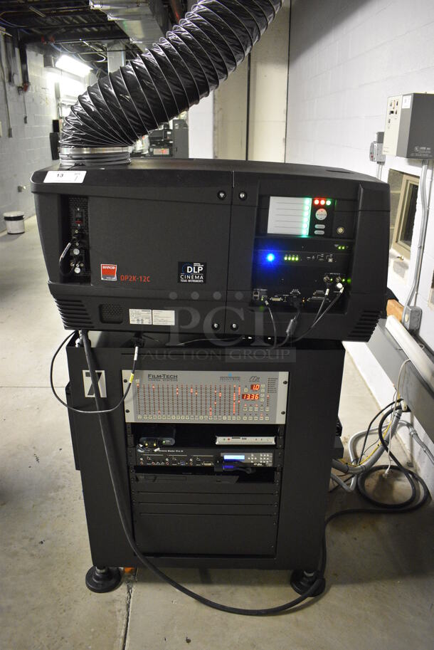 MARVELOUS! 2015 Barco Model DP2K-12C Commercial Countertop DLP Cinema Projector on Cabinet w/ Film-Tech FT21 Automation Cinema System, Gefer Cinema Scaler Pro III, Dolby CP750 Digital Cinema Processor, DCM Powercom, TV Monitor and Tripp Lite Surge Protector. 200-240 Volts. See Lot 14 For Additional Pictures! 26x38x22, 24x53x38. BUYER MUST REMOVE. Tested and Working! - Image 1 of 12