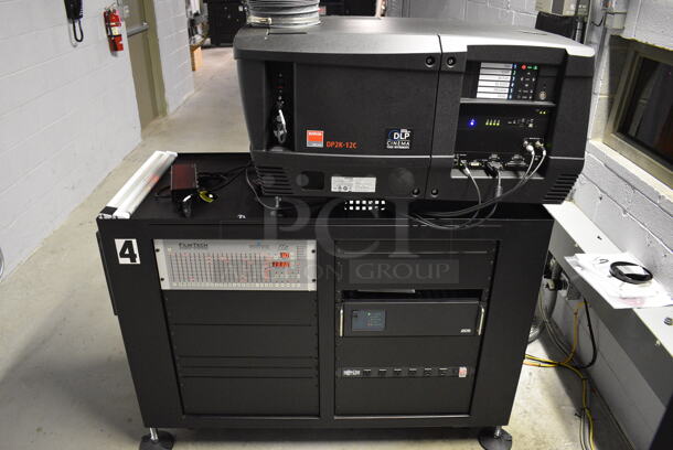MARVELOUS! 2014 Barco Model DP2K-12C Commercial Countertop DLP Cinema Projector on Cabinet w/ Film-Tech FT21 Automation Cinema System, Gefer Cinema Scaler Pro III, Dolby CP750 Digital Cinema Processor, DCM Powercom, TV Monitor and Tripp Lite Surge Protector. 200-240 Volts. See Lot 16 For Additional Pictures! 26x38x22, 24x53x38. BUYER MUST REMOVE. Tested and Working! - Image 1 of 12
