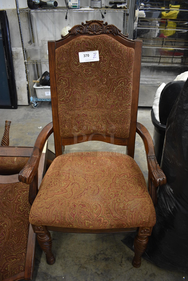 2 Wooden Dining Chairs w/ Arm Rests, Brown Patterned Seat and Backrest. One Has Broken Leg. 26x21x47. 2 Times Your Bid!