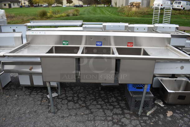 BRAND NEW SCRATCH AND DENT! Regency Stainless Steel Commercial 3 Bay Sink w/ Dual Drainboards. One Leg Needs Reattached. 94x29x45. Bays 18x24x14. Drainboards 16x26x2 - Image 1 of 6