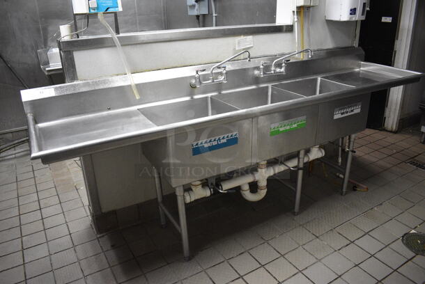 Stainless Steel Commercial 3 Bay Sink w/ Dual Drainboards, Faucets and Handles. BUYER MUST REMOVE. 108x26x41.5. Bays 20x20x12. Drainbaords 22x22x2