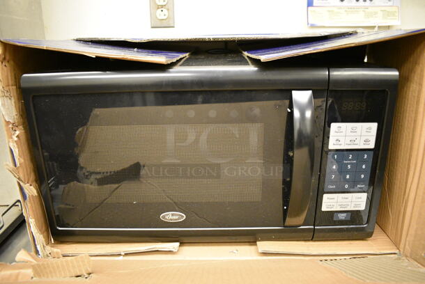 IN ORIGINAL BOX! Oster Countertop Microwave. 21x16x12 - Image 1 of 5