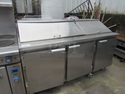 One Delfield 3 Door Prep Table, With 2 Racks,  On Casters. 72X32X45. Working Not Cold.