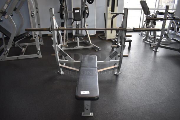 NICE! Hammer Strength Gray Metal Floor Style Flat Back Bench Press w/ Olympic Bar. BUYER MUST REMOVE - Unit May Need Disassembly For Removal. 67x63x51. (weight room)