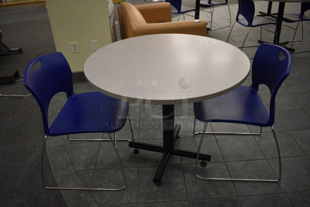 Gray Round Table on Metal Table Base and 2 Blue Chairs. 36x36x30, 20x21x31. (lobby)