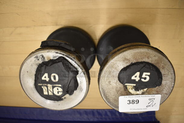 2 Black and Chrome Finish Metal Dumbbells. 40 Pounds and 45 Pounds. BUYER MUST REMOVE. 8x10.5x8. 2 Times Your Bid! (behind squash court - left) - Image 1 of 2