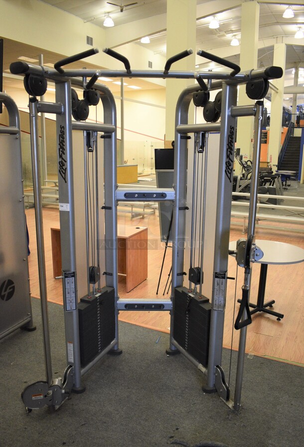 Life Fitness Model CMDAP Gray Metal Floor Style Dual Adjustable Pulley Functional Trainer Machine. BUYER MUST REMOVE BUYER MUST REMOVE - Unit May Need Disassembly For Removal. 64x48x93. (lobby)