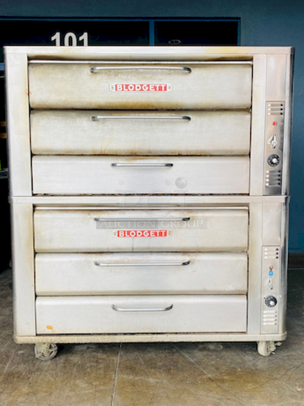 PRISTINE!! Blodgett 981 Natural Gas Multi-Purpose Double Deck Oven with Draft Diverter - 100,000 BTU. On Commercial Casters.    Can be used for: roasts, pastries, cakes, artesian breads, pizzas, and more 42"W x 32"D deck interior, (4) sections, consists of (4) 7" high baking compartments per section, (FTDO) 200-500°F mechanical thermostat, counter-balanced doors with heavy chrome handle, angle iron frame, steel deck, crown angle trim, aluminized steel interior, stainless steel top, front, sides and back  Overall Dimensions: Width: 60" Depth: 38 1/2" Height: 68 13/16" Interior Dimensions (Per Oven): Width: 42" Depth: 32" Height: 7" Deck Thickness: 1" - Image 1 of 11