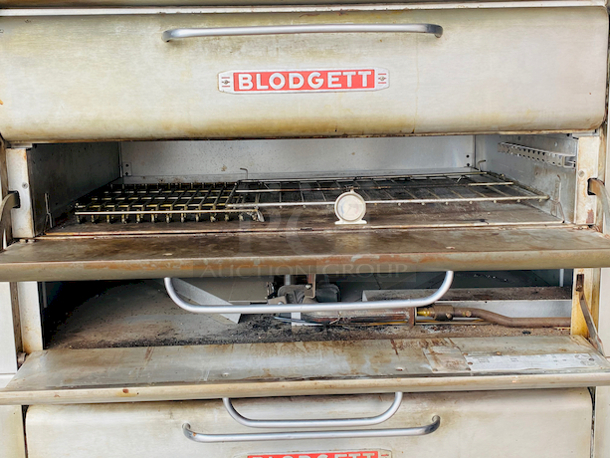 PRISTINE!! Blodgett 981 Natural Gas Multi-Purpose Double Deck Oven with Draft Diverter - 100,000 BTU. On Commercial Casters.    Can be used for: roasts, pastries, cakes, artesian breads, pizzas, and more 42"W x 32"D deck interior, (4) sections, consists of (4) 7" high baking compartments per section, (FTDO) 200-500°F mechanical thermostat, counter-balanced doors with heavy chrome handle, angle iron frame, steel deck, crown angle trim, aluminized steel interior, stainless steel top, front, sides and back  Overall Dimensions: Width: 60" Depth: 38 1/2" Height: 68 13/16" Interior Dimensions (Per Oven): Width: 42" Depth: 32" Height: 7" Deck Thickness: 1" - Image 6 of 11