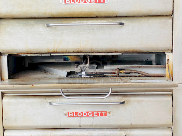 PRISTINE!! Blodgett 981 Natural Gas Multi-Purpose Double Deck Oven with Draft Diverter - 100,000 BTU. On Commercial Casters.    Can be used for: roasts, pastries, cakes, artesian breads, pizzas, and more 42"W x 32"D deck interior, (4) sections, consists of (4) 7" high baking compartments per section, (FTDO) 200-500°F mechanical thermostat, counter-balanced doors with heavy chrome handle, angle iron frame, steel deck, crown angle trim, aluminized steel interior, stainless steel top, front, sides and back  Overall Dimensions: Width: 60" Depth: 38 1/2" Height: 68 13/16" Interior Dimensions (Per Oven): Width: 42" Depth: 32" Height: 7" Deck Thickness: 1" - Image 7 of 11
