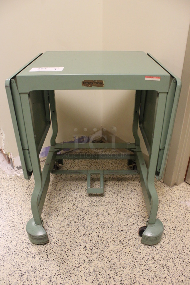 Green Metal Table on Casters. 20x18x27. (Hallway To The Right of Atrium Lobby)