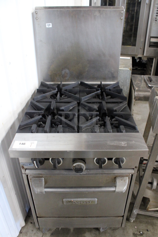 Garland Stainless Steel Commercial Natural Gas Powered 4 Burner Range w/ Oven and Backsplash on Commercial Casters. 24x35x57