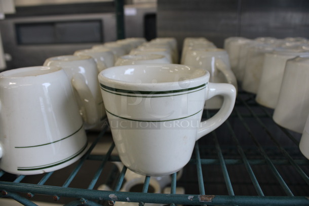 19 White Ceramic Mugs w/ Green Lines on Rim. 4x3x3. 19 Times Your Bid!