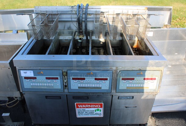 Henny Penny Model LVG-SSS Stainless Steel Commercial Floor Style Natural Gas Powered 3 Bay Deep Fat Fryer w/ 6 Metal Fry Baskets on Commercial Casters. 225,000 BTU. 47x32x48