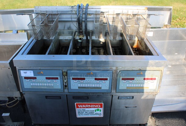 Henny Penny Model LVG-SSS Stainless Steel Commercial Floor Style Natural Gas Powered 3 Bay Deep Fat Fryer w/ 6 Metal Fry Baskets on Commercial Casters. 225,000 BTU. 47x32x48 - Image 1 of 8