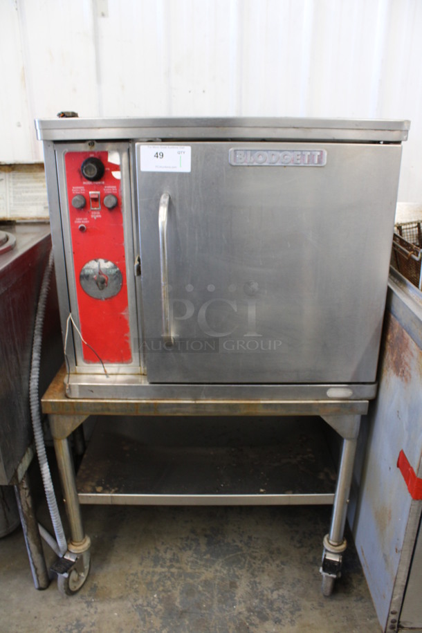 Blodgett Stainless Steel Commercial Electric Powered Half Size Convection Oven w/ Solid Door and Metal Oven Racks on Commercial Casters. 208-220 Volts, 1 Phase. 30x26x50.5