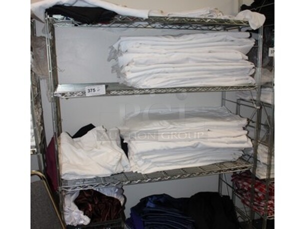 ALL ONE MONEY! Metal Shelving Unit with Mixture of Linens and Table Cloths. Winning Bidder Can Take What They Want From Lot!
