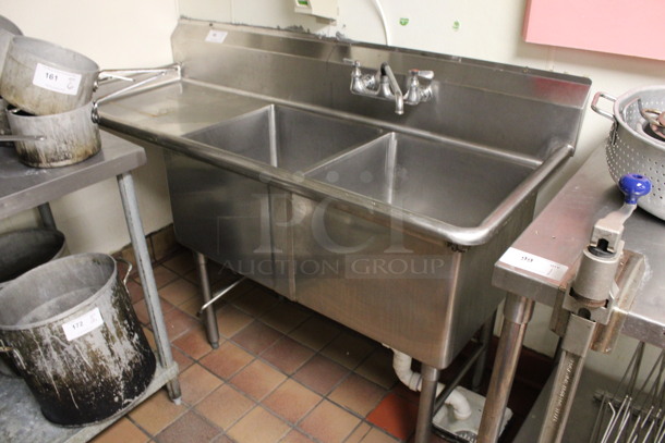 Stainless Steel Commercial 2 Bay Sink w/ Left Side Drainboard, Faucet and Handles. BUYER MUST REMOVE. 66.5x26.5x42. Bays 19x20x14. Drainboard 22x22x2. (kitchen)