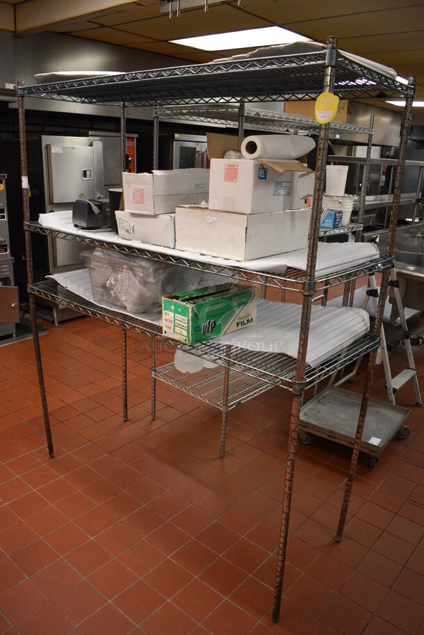 Chrome Finish 3 Tier Shelving Unit w/ Contents Including Edlund Knife Sharpener and Various Paper Products. BUYER MUST DISMANTLE. PCI CANNOT DISMANTLE FOR SHIPPING. PLEASE CONSIDER FREIGHT CHARGES. 60x24x74. (kitchen)