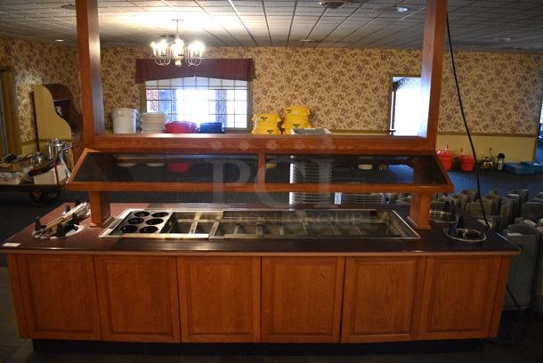 Portable Buffet Station w/ 4 Plate Return Chutes, Sneeze Guard and Wooden Exterior on Commercial Casters. 135x42x98. Unit Was In Working Condition When Restaurant Closed. BUYER MUST REMOVE. (buffet)