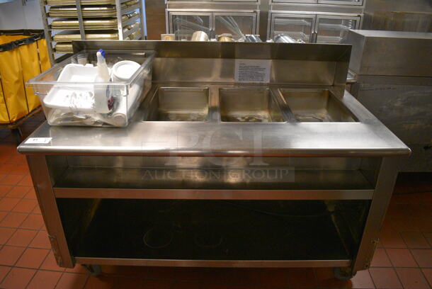 Stainless Steel Commercial Electric Powered 4 Bay Steam Table w/ Under Shelf and Bin of Various Paper Products on Commercial Casters. 64x36x46. Unit Was In Working Condition When Restaurant Closed. (kitchen)