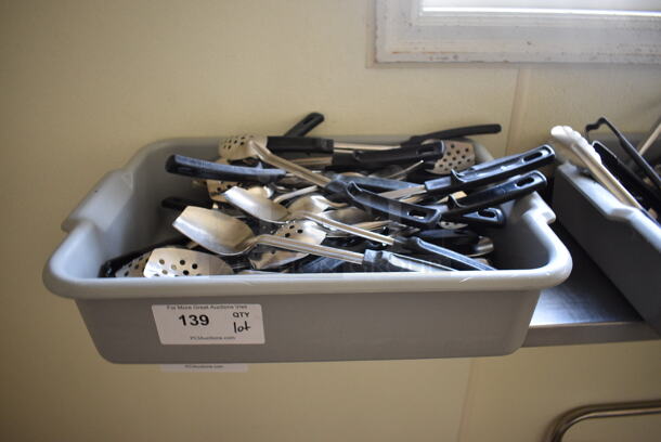ALL ONE MONEY! Lot of Various Utensils Including Straining Serving Spoons in Gray Bus Bin! 21x15x5. (kitchen hallway)