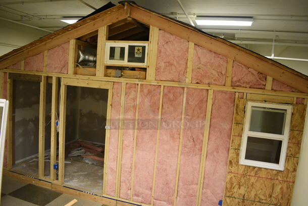 Wooden Small Demo House Frame w/ Insulation, Windows, Ruud Unit, Square D Switch. BUYER MUST REMOVE: Winning Bidder Will Have To Contact HACC To Make an Appointment To Remove This Item Between May 6th and May 13th. 24'X12'X12.5'. (room 103)