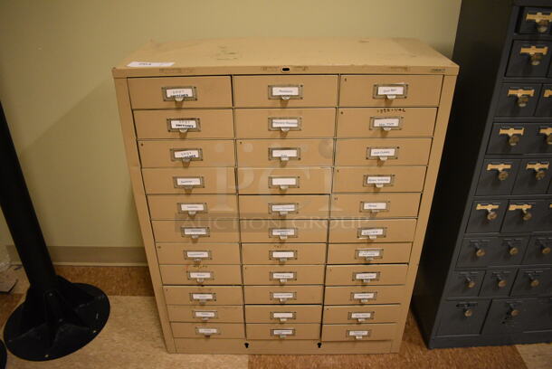 Tan Metal 33 Drawer Filing Cabinet w/ Contents. BUYER MUST REMOVE: Give Yourself Ample Time To Remove This Item on Pick Up Day. 30.5x13x38. (room 108a)