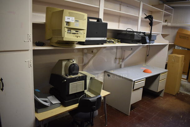 ALL ONE MONEY! Wall Lot of Various Items Including Table, Chair, Desk, Over Head Projectors, Dukane Micromatic II and Apple Computer Monitor. BUYER MUST REMOVE. (Clearview Elementary - Lower Level Room 13)