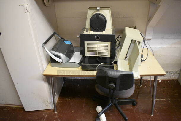ALL ONE MONEY! Wall Lot of Various Items Including Table, Chair, Desk, Over Head Projectors, Dukane Micromatic II and Apple Computer Monitor. BUYER MUST REMOVE. (Clearview Elementary - Lower Level Room 13) - Image 2 of 7