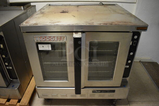 Blodgett Stainless Steel Commercial Full Size Convection Oven w/ View Through Doors, Metal Oven Racks and Thermostatic Controls on Commercial Casters. Goes GREAT w/ Lot 8! BUYER MUST REMOVE. 38.5x41x38. (Clearview Elementary - Upstairs Hallway)